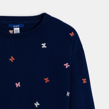 كنزة زرقاء اللون، ومُطرزة برسمة فراشة للفتيات